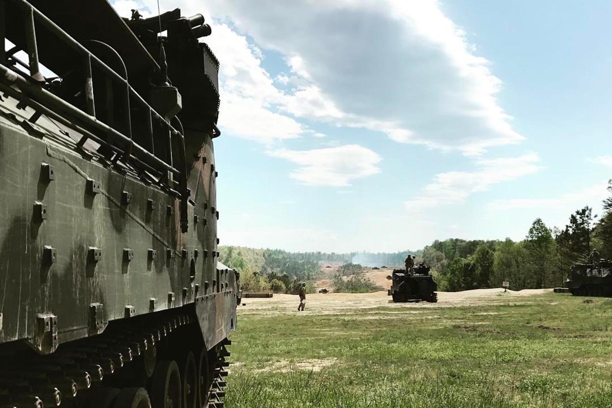 Army tanks rolling through an open field
