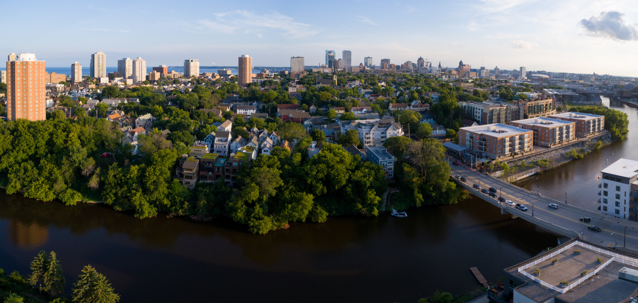 City skyline with a river and trees, illustrating Milwaukee's efforts to combat flooding through the Greenseams program.