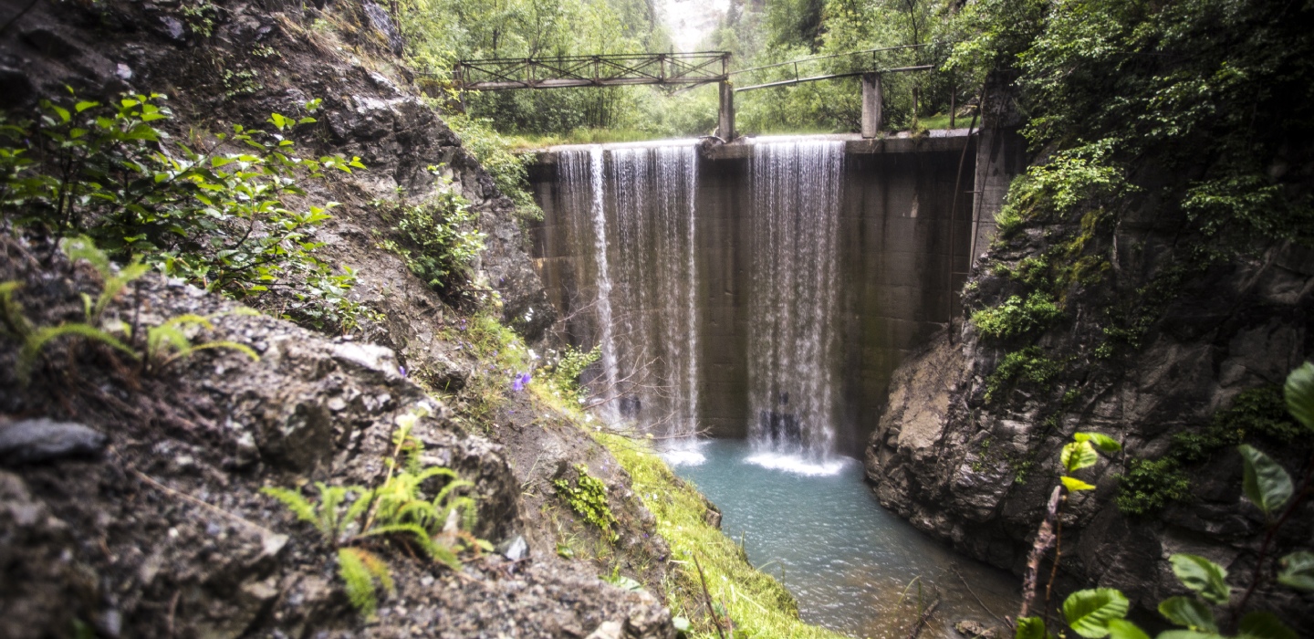 An abandoned dam with water trickling through.