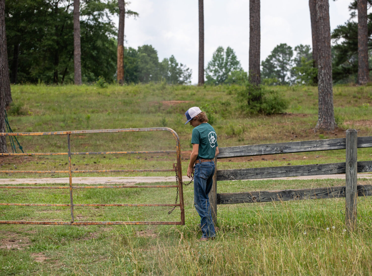 A young boy unlocks a gate on his family farm in Georgia
