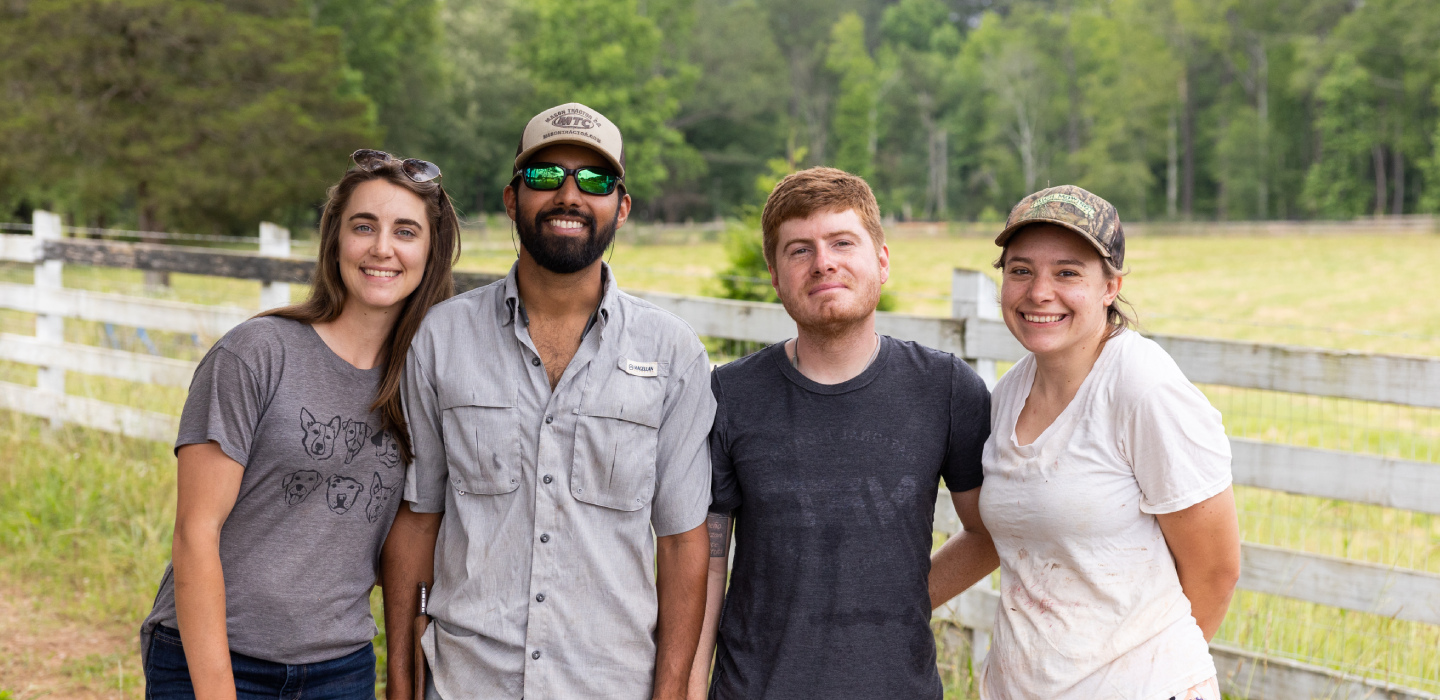 Four people pose on their farm in Georgia