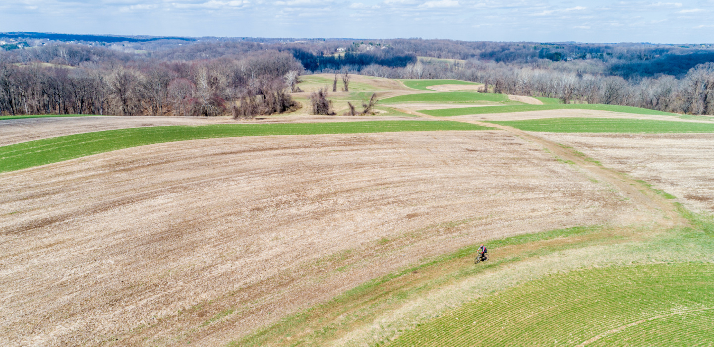 A person bikes across a prairie