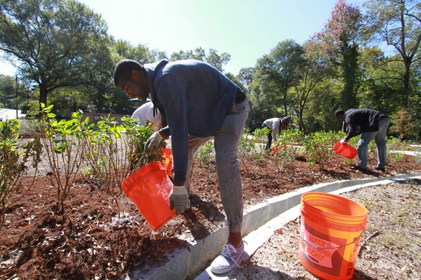 A man lays down dirt in a new garden at Lindsay Street Park