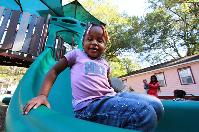 A young community member enjoying the Lindsay Street Park playground equipment!