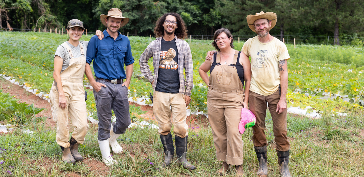 Five people pose on their farmland at Love is Love Farm in Georgia