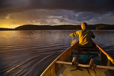 Man in boat on Minnesota lake in Boundary Waters Canoe Area Wilderness