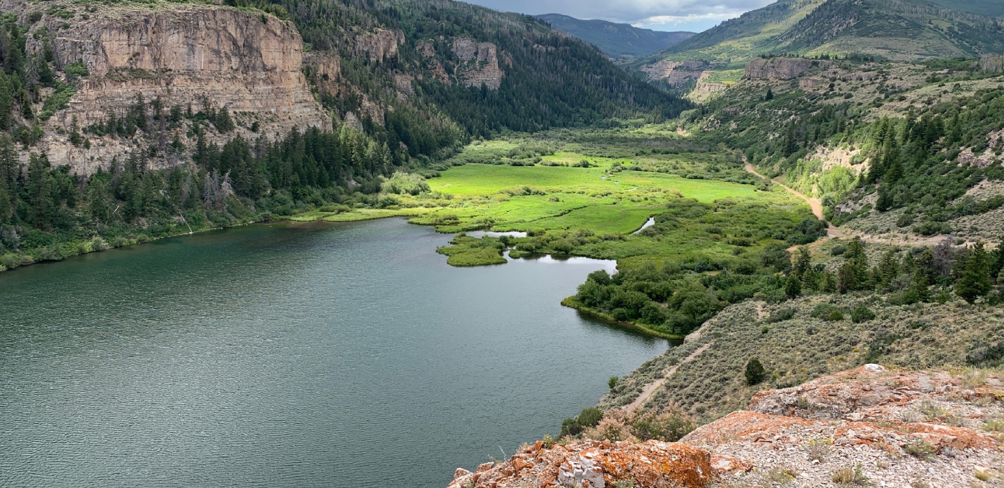Sweetwater Lake, Colorado with trees, grasses and mountains surrounding