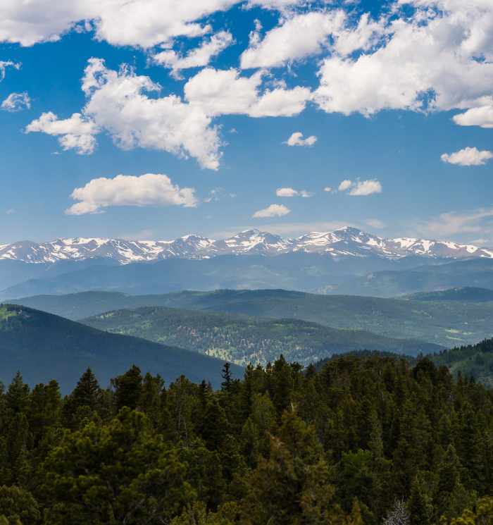 A cloudy blue sky with mountains visible in the background, creating a serene and picturesque landscape.