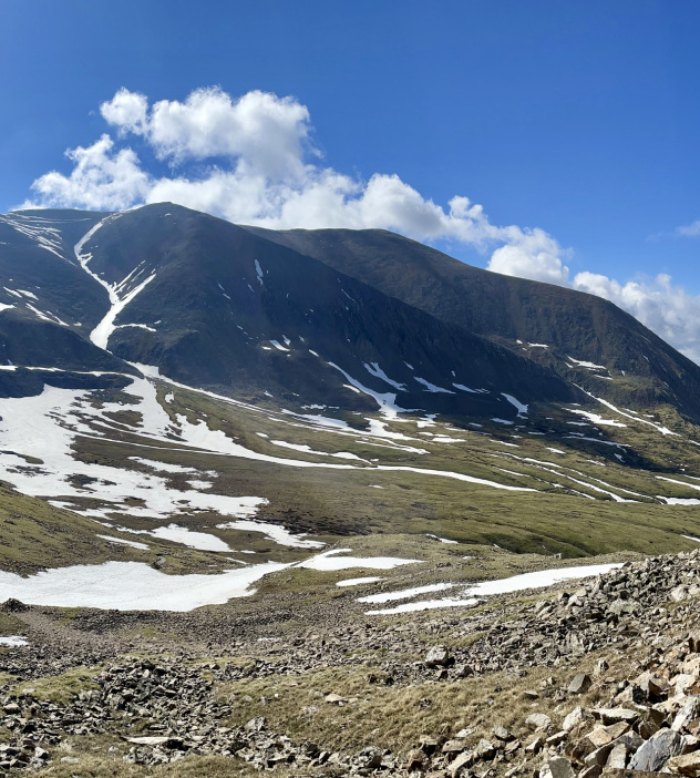 Scenic view of Mt. Democrat featuring snow-covered peaks and rocky ground.