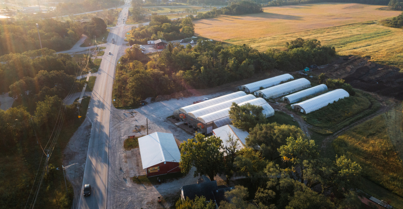 Aerial view of Z Farm, now owned by Urban Growers Collective, featuring multiple barns and green fields on Chicago's South Side.